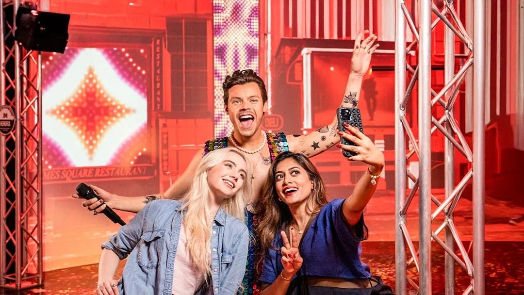 Two women taking a selfie with Harry Styles's wax figure at Madame Tussauds, New York.