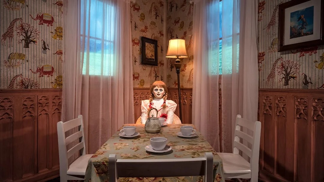 Wax figure of Annabelle from The Conjuring at a tea table in Madame Tussauds, New York horror zone.