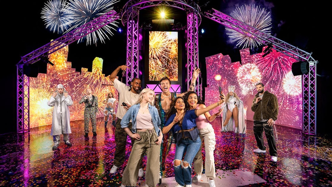 Guests posing with wax figures of musical artists at Madame Tussauds, New York.