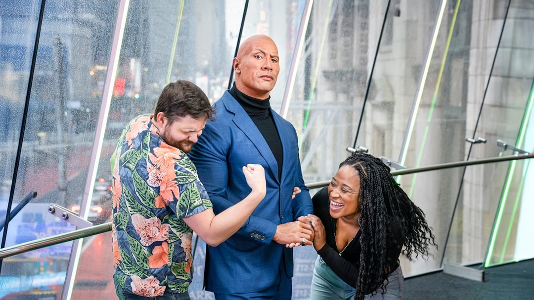 Couple posing with Dwayne Johnson wax figure at Madame Tussauds, New York.