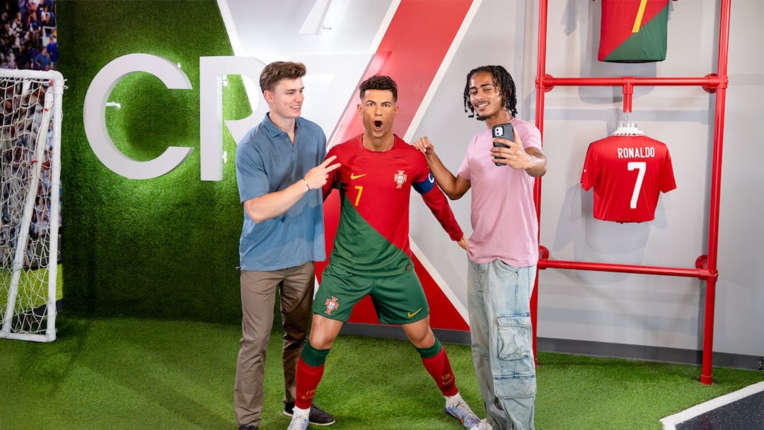 Two men taking a selfie with Ronaldo's wax figure at Madame Tussauds, New York.