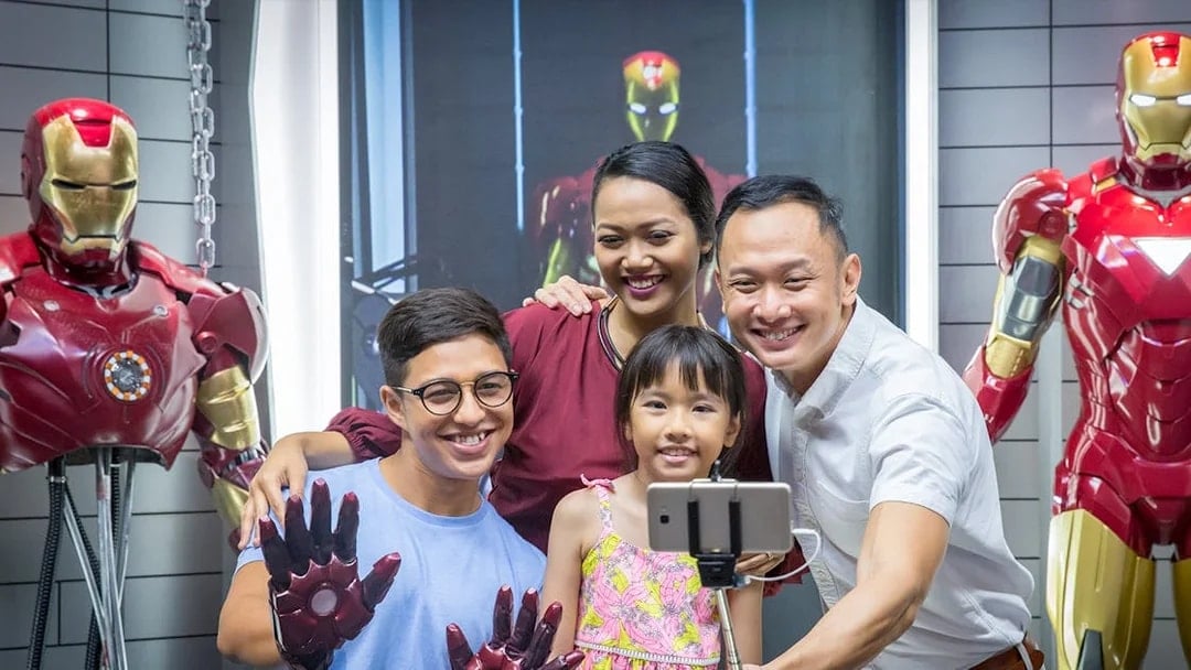 Family taking selfie with Iron Man figures at Madame Tussauds Singapore.