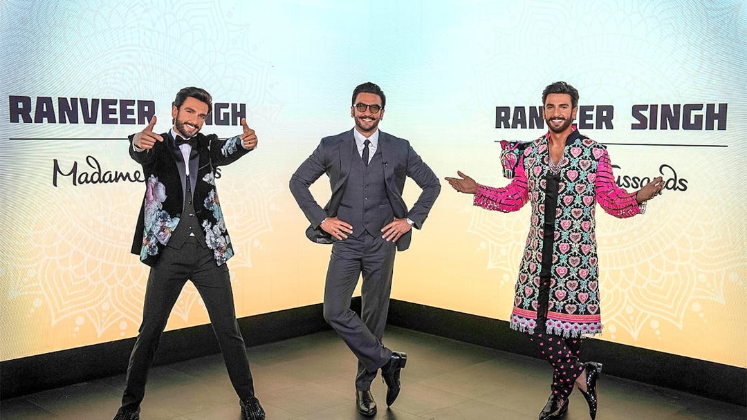 Wax figures of a celebrity in various outfits at Madame Tussauds Singapore.