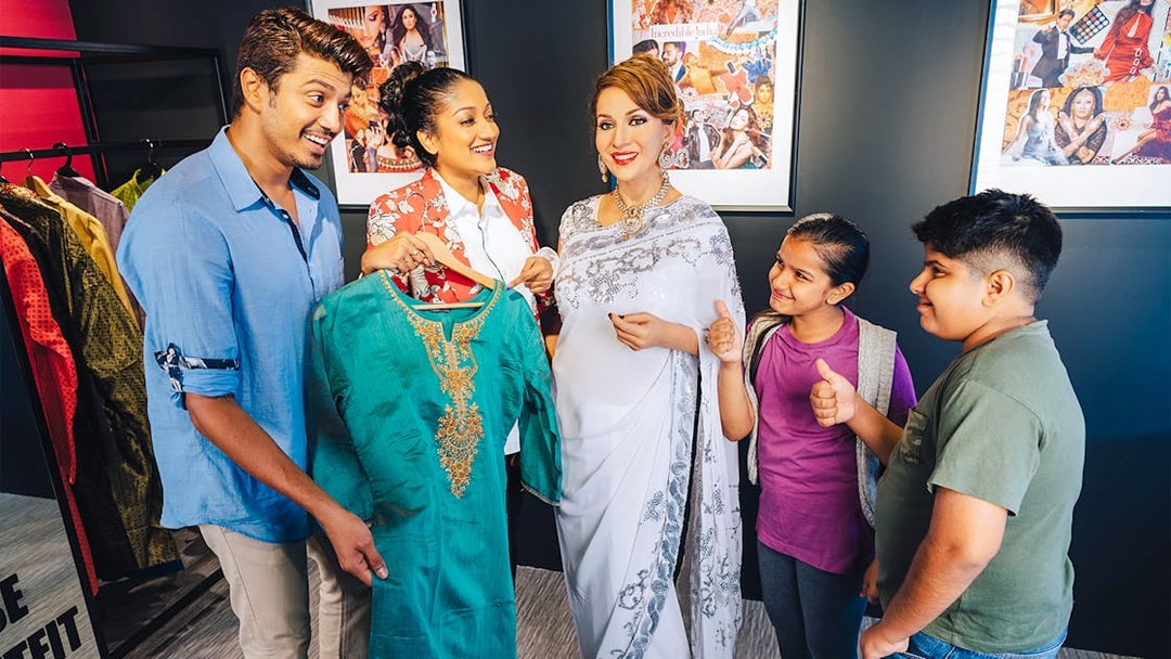 Wax figures of famous personalities with visitors at Madame Tussauds Singapore.