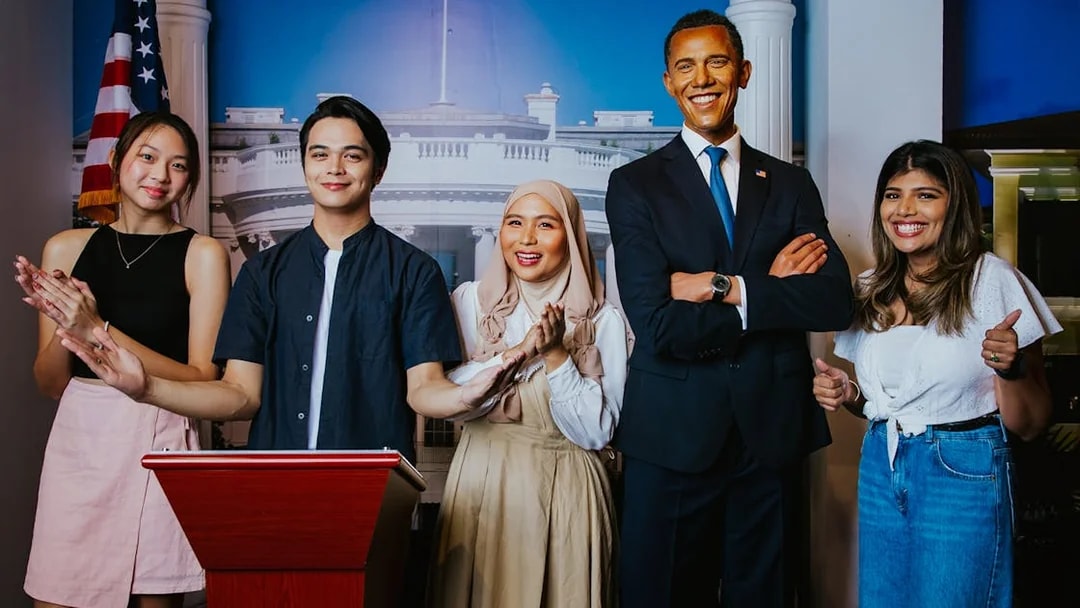 Visitors posing with Obama wax figure at Madame Tussauds Singapore.