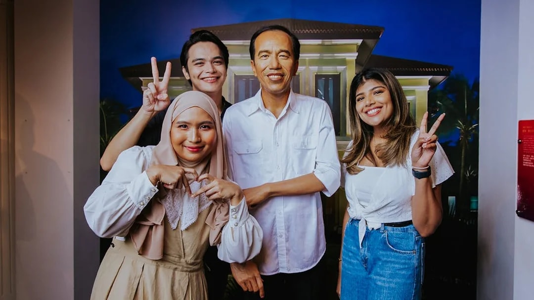 Visitors posing with a wax figure at Madame Tussauds Singapore.