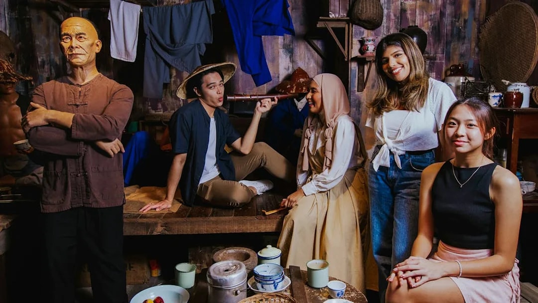 Visitors interacting in the Coolie Quarters exhibit at Madame Tussauds Singapore.