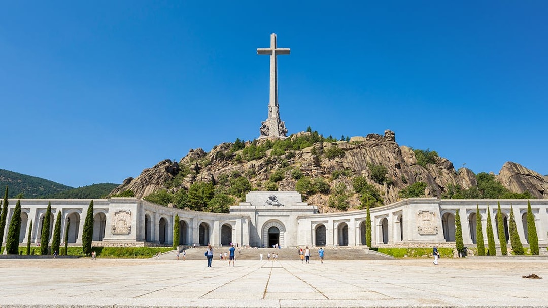 Valley of the Fallen monument with large cross and surrounding colonnade in Spain.