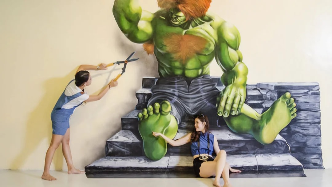 Visitors interacting with a 3D mural of a green giant at Magic Art 3D Museum.
