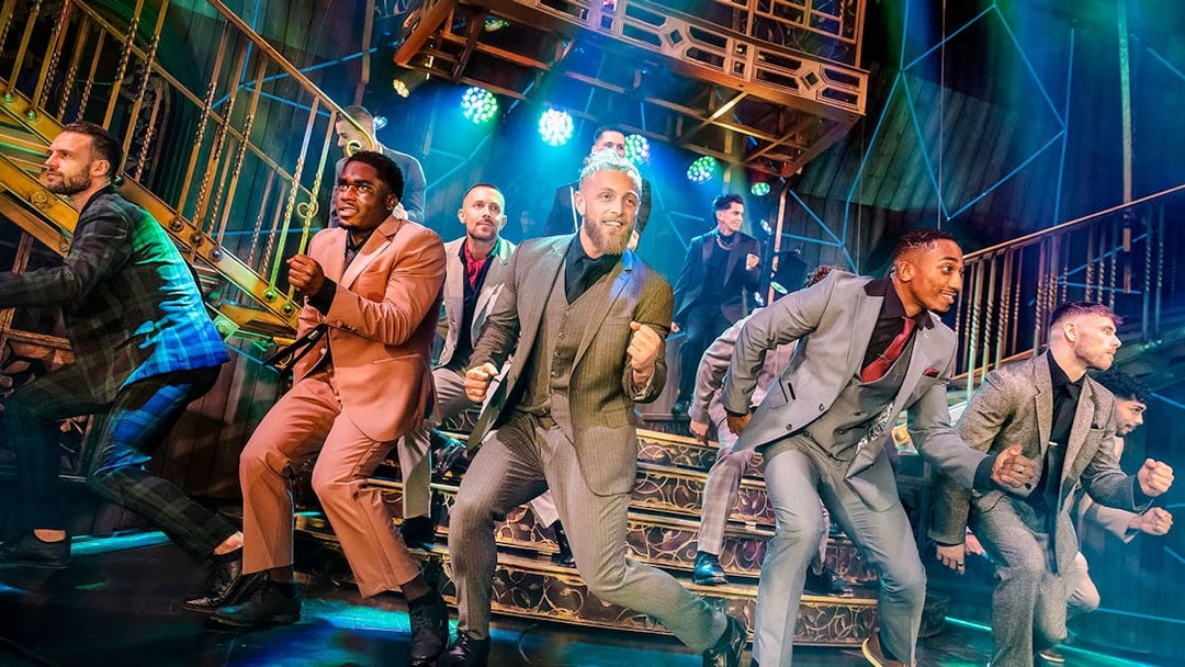 Performers dancing energetically on stage during Magic Mike Live show.