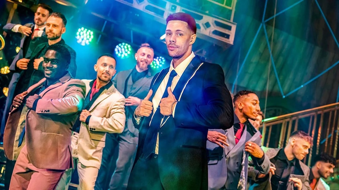 Performers in suits on stage at Magic Mike Live show.