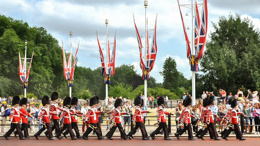 Guards marching in London with Union Jack flags, part of the Magic of London Tour.