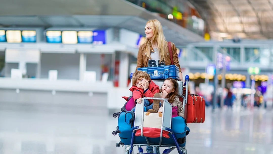 Family with luggage at airport, ready for shuttle service to Disneyland Paris from CDG/ORY.