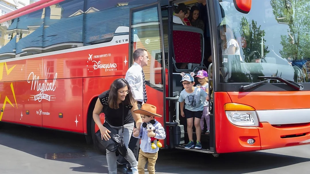 Families disembark Magic Shuttle bus at Disneyland Paris entrance.