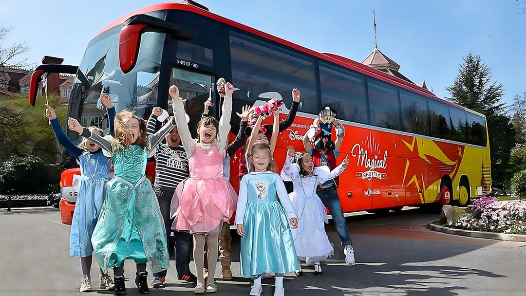 Young girls in costumes celebrating near the Magical Shuttle at Disneyland Paris.