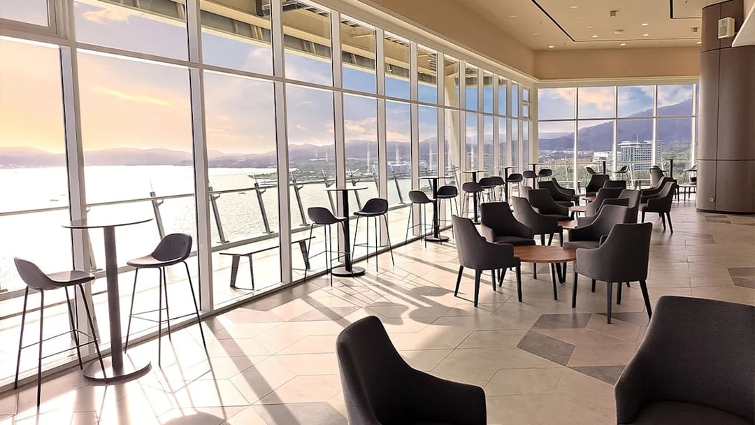 Spacious lounge with panoramic views of the sea and mountains at Maha Tower, Malaysia.