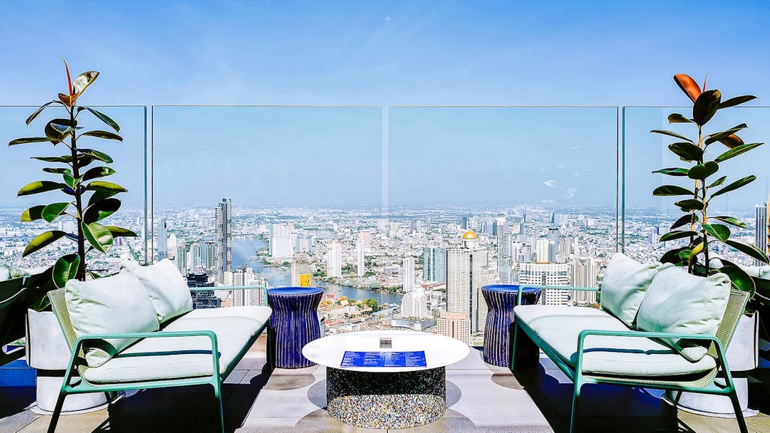 Rooftop seating area overlooking Bangkok skyline from Mahanakhon SkyWalk, Thailand.