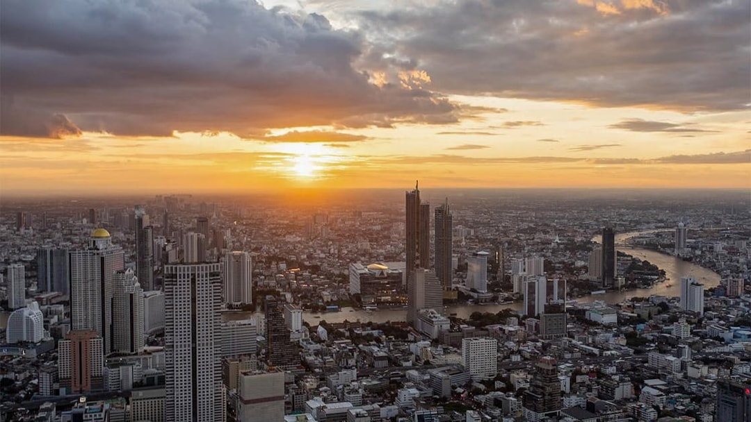 Aerial view of Bangkok skyline from Mahanakhon SkyWalk at sunset.