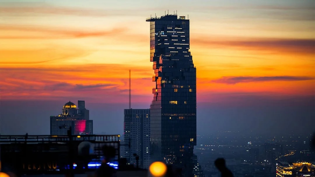 Aerial view of Mahanakhon SkyWalk at sunset in Bangkok.