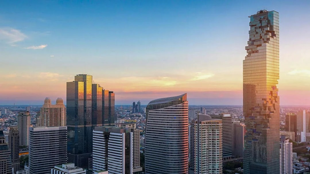 Mahanakhon SkyWalk view of Bangkok skyline at sunset.