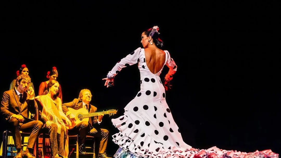 Flamenco dancer performing with musicians on stage at Esencia show.