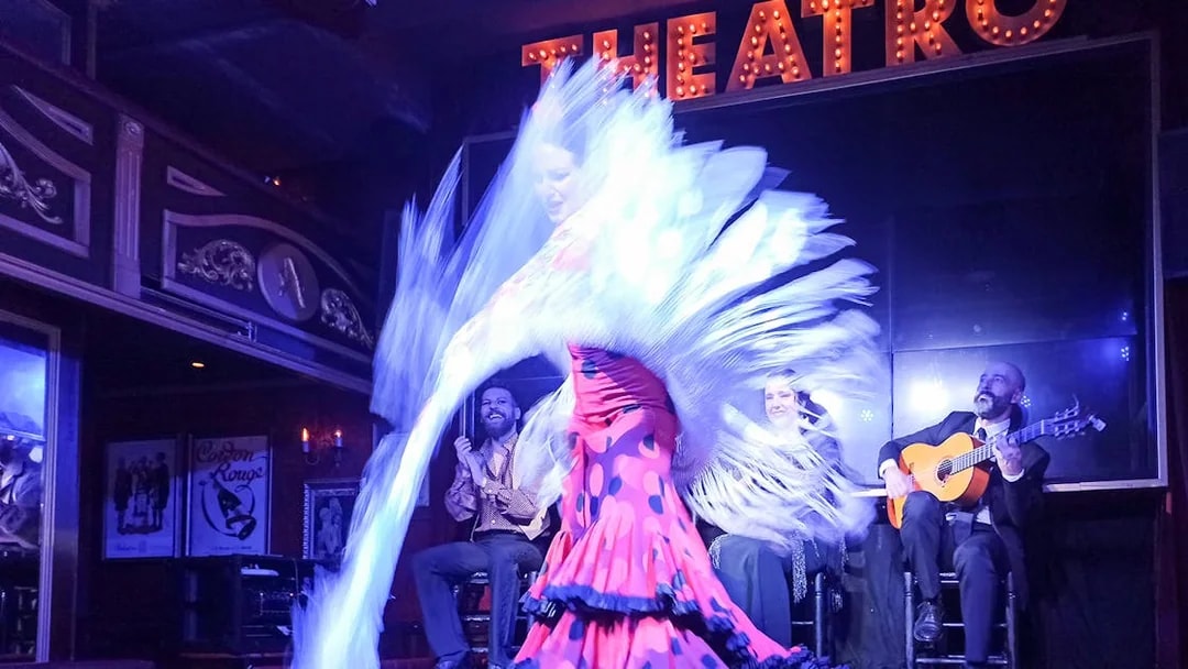 Flamenco dancer performing with musicians on stage at Esencia show.