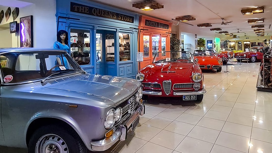 Classic cars and motorcycles displayed in a vintage-themed showroom.