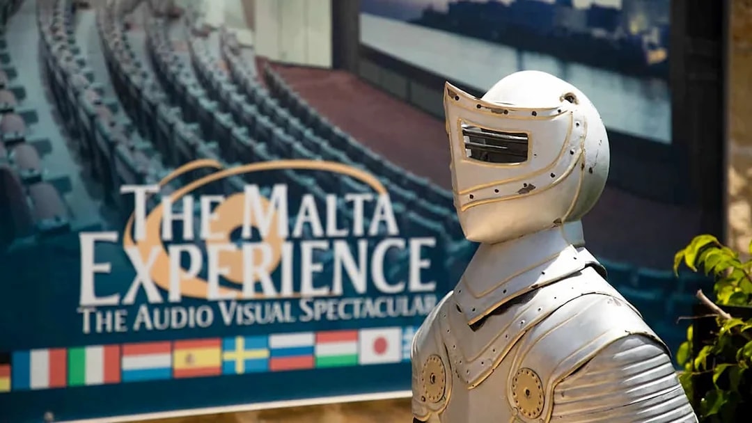 Knight armor statue in front of The Malta Experience sign, Valletta.