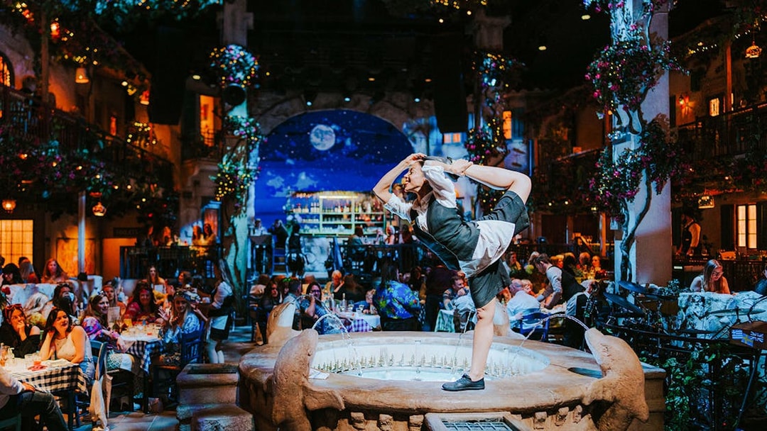 Performer dancing on a fountain at Mamma Mia! The Party event.