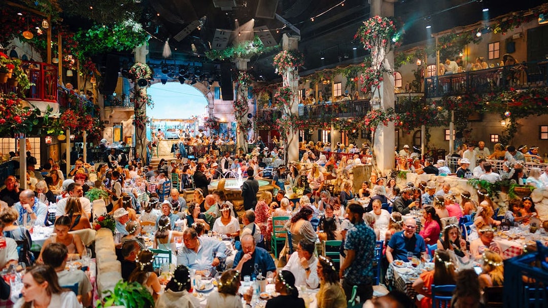 Guests dining at Mamma Mia! The Party with vibrant decor and lively atmosphere.