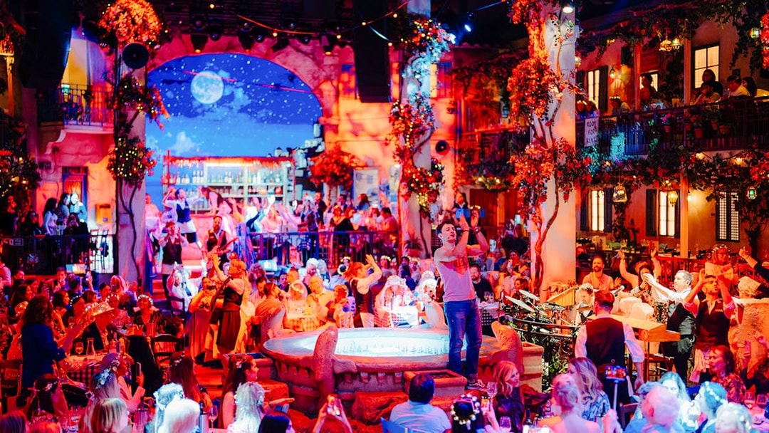 Guests enjoying Mamma Mia! The Party with lively performances and vibrant decor.