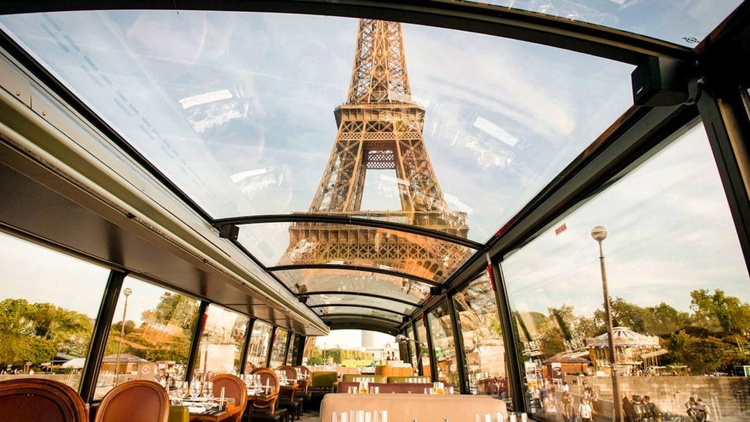 Interior view of La Marina Orsay lunch cruise with Eiffel Tower through glass ceiling, Paris.
