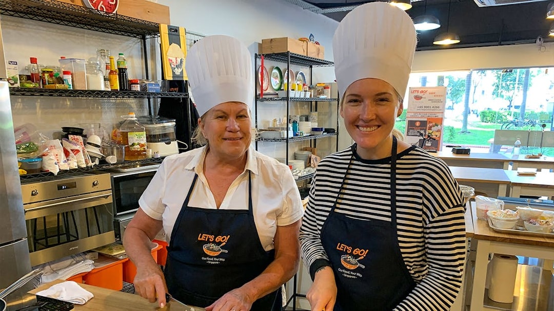 Culinary tour participants chopping ingredients in a kitchen during a Market to Table experience.