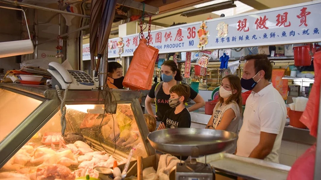 Market tour group observing meat display at a local vendor.