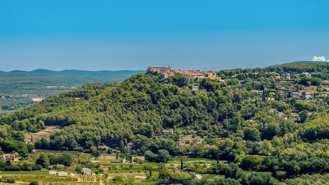 Hilltop village surrounded by vineyards in Bandol, France, under a clear blue sky.