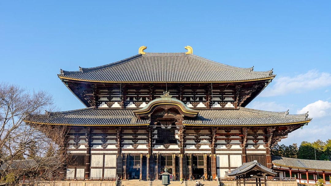 Tōdai-ji Temple's Great Buddha Hall in Nara, Japan, with visitors exploring the grounds.
