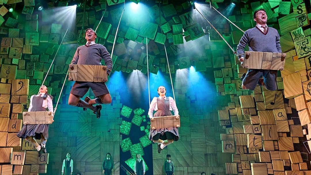 Performers on swings during a scene from Matilda The Musical.