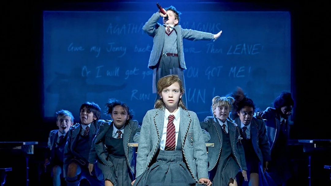 Children performing a scene from Matilda The Musical on stage.
