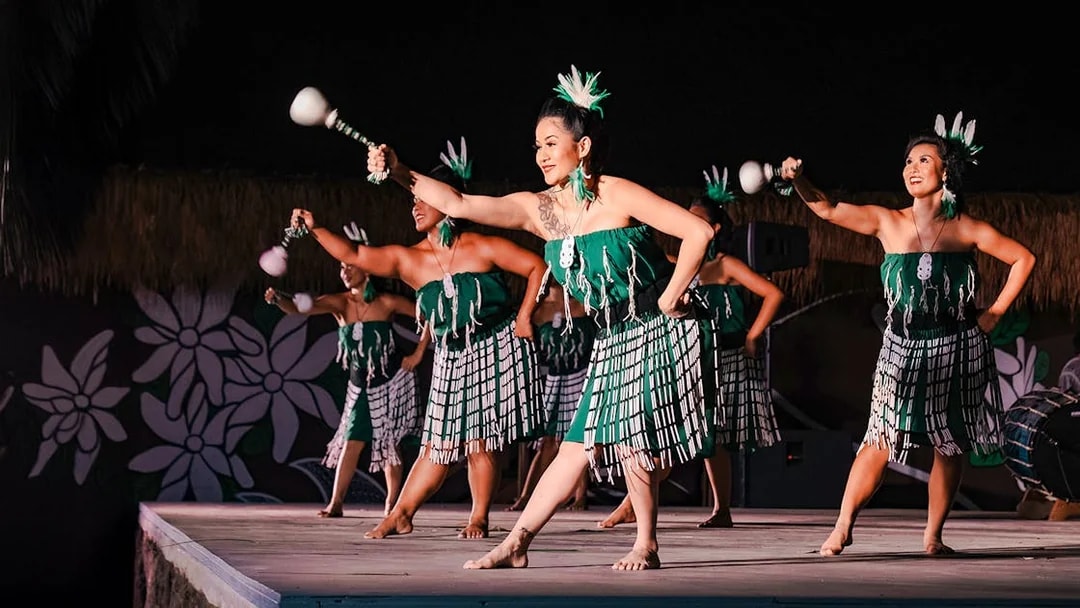 Traditional Polynesian women performing Poi dance on stage.