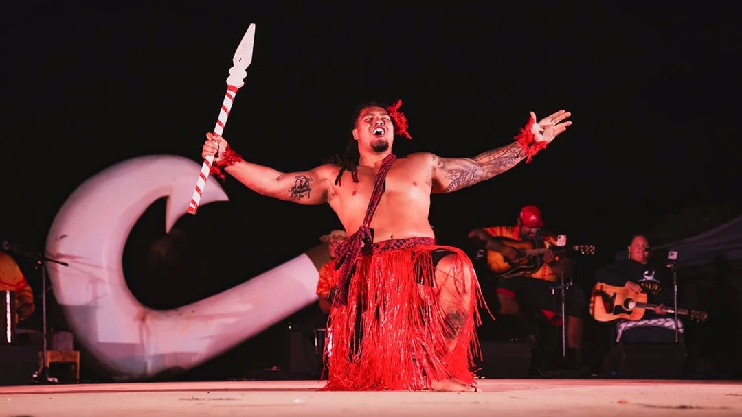 Mauka Warrior performing traditional dance on stage at a Luau.