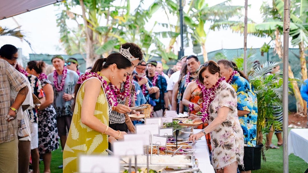 Guests serving themselves at a buffet of Polynesian food at Mauka Warriors Luau.