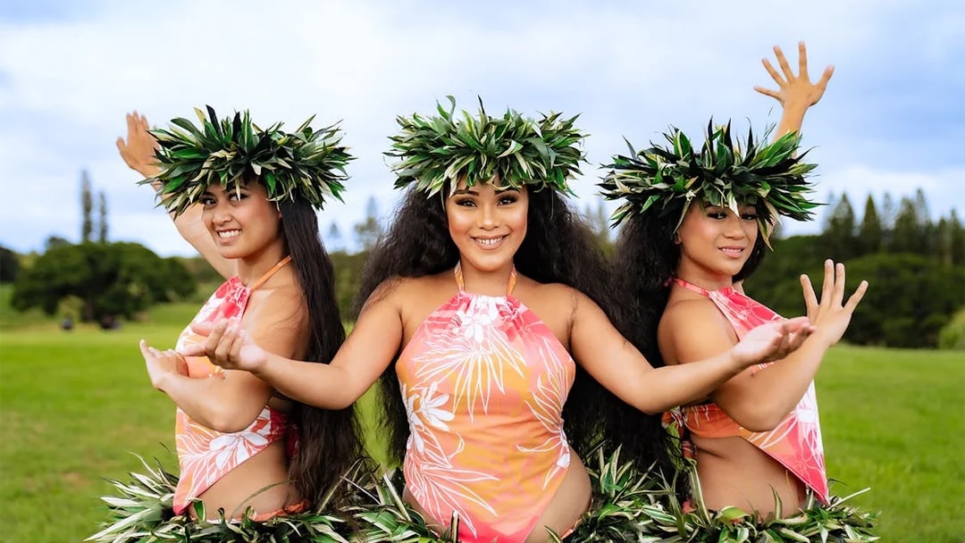 Dancers performing at Mauka Warriors Luau in traditional attire with greenery backdrop.