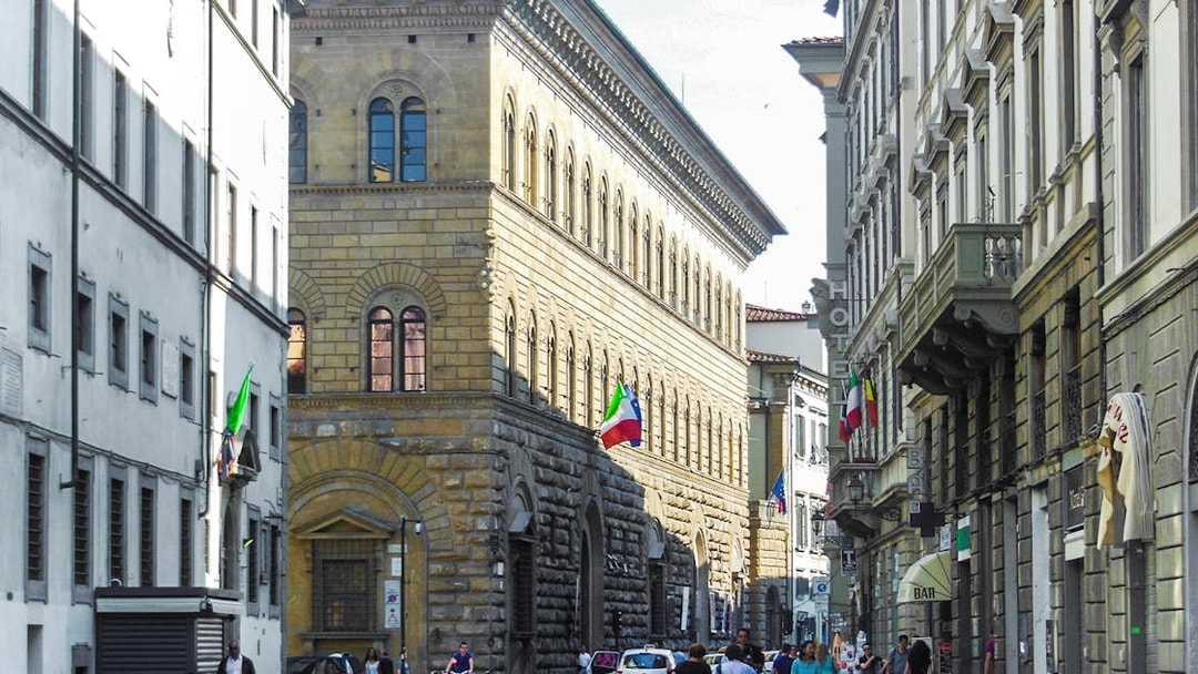 Palazzo Medici Riccardi street view with Italian flags in Florence, Italy.
