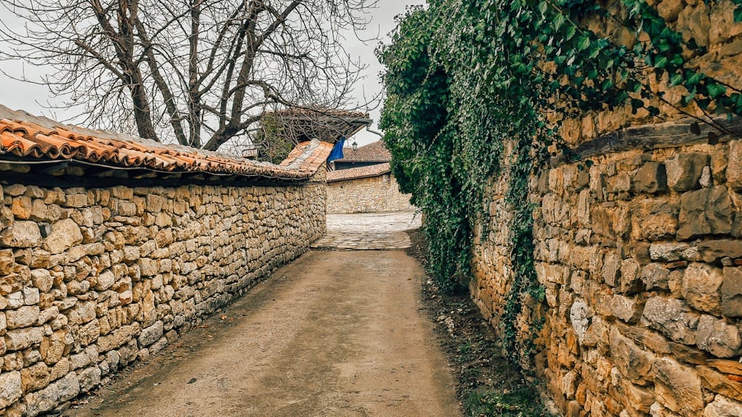 Medieval stone pathway in Bulgaria with ivy-covered walls.