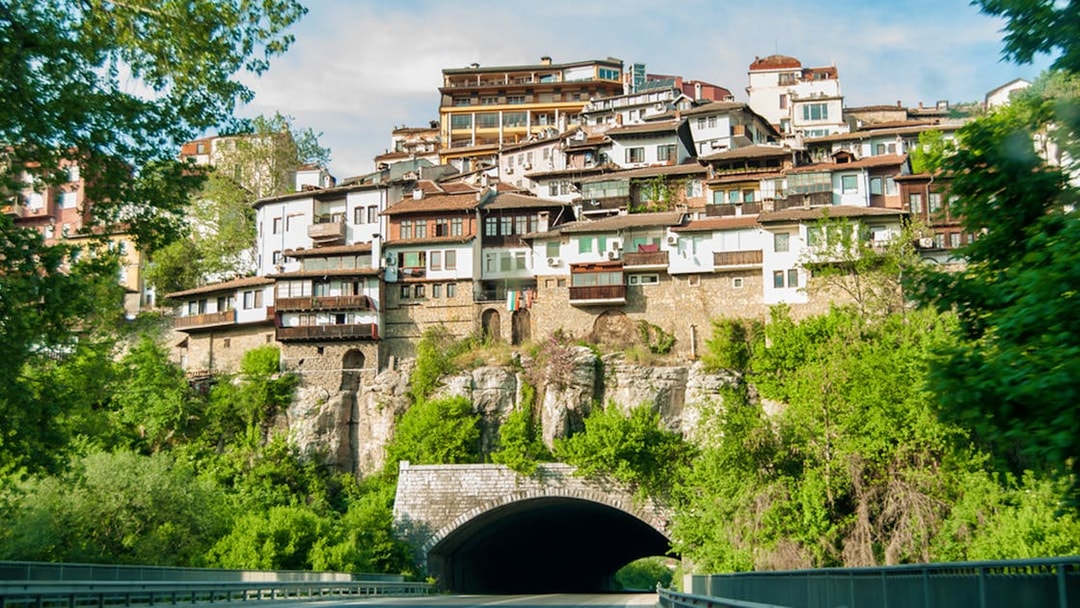 Houses on a cliff in Veliko Tarnovo, Bulgaria, seen from a road below.