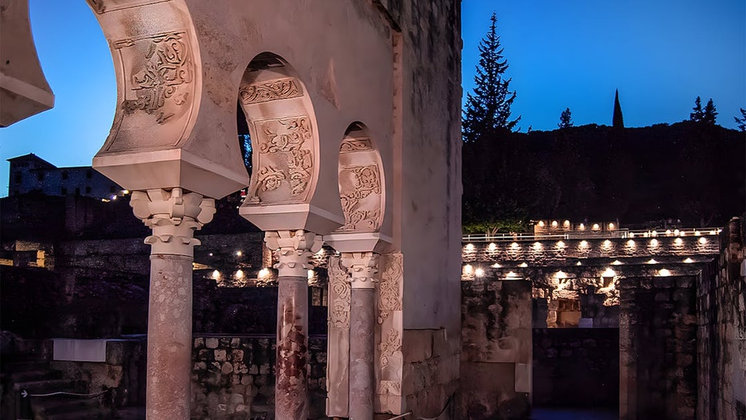 Arched columns illuminated at night in Medina Azahara, Córdoba.
