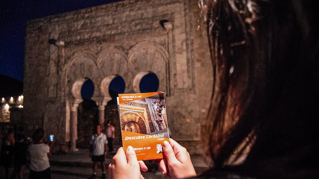 Guided night tour at Medina Azahara with visitors holding a Córdoba map.