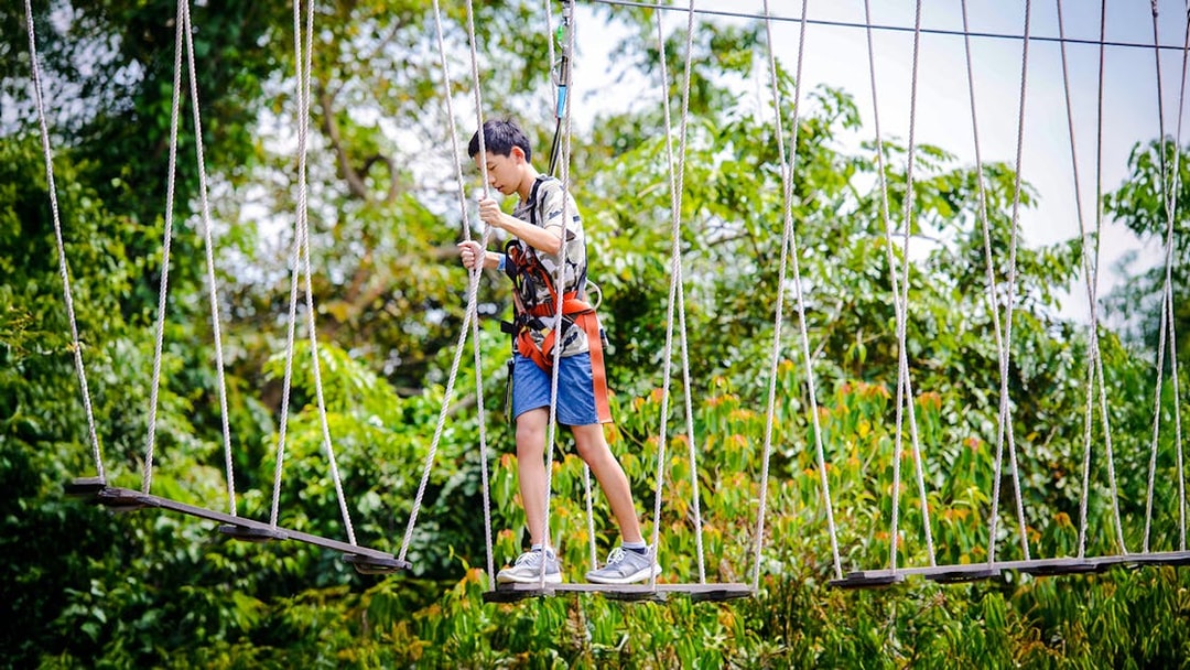 Participant crossing rope bridge at Mega Adventure Park Singapore.