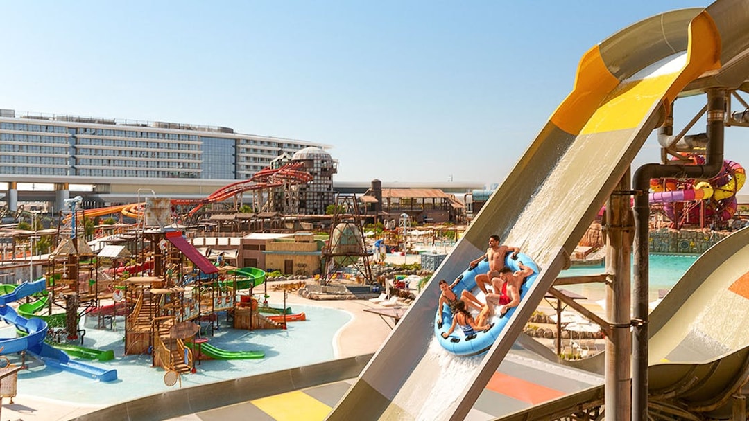 Visitors on a raft sliding down a water ride at Meryal Waterpark.