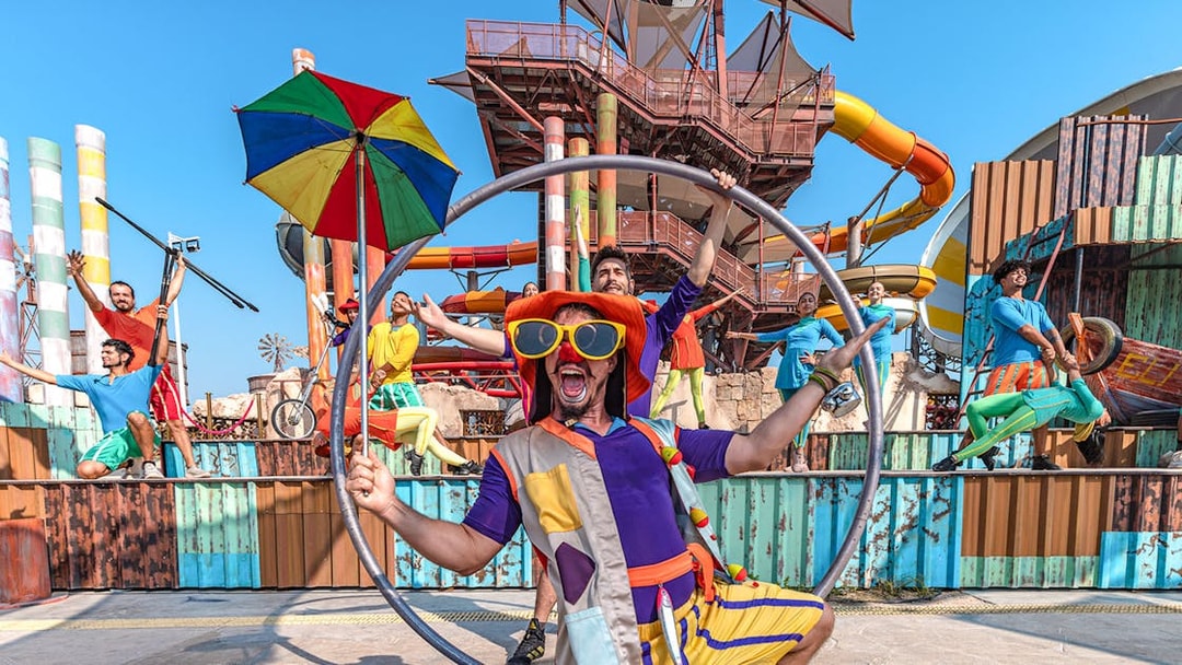 Performers at entertainment event in Meryal Waterpark with colorful costumes and props.